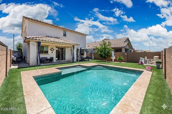 a view of a house with swimming pool and a yard