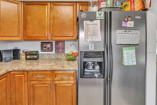 a kitchen with stainless steel appliances granite countertop a refrigerator and cabinets