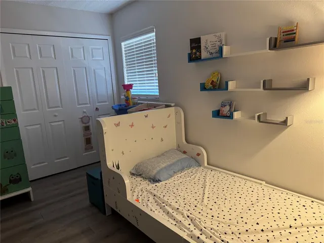 a bedroom with a bed and wooden floor