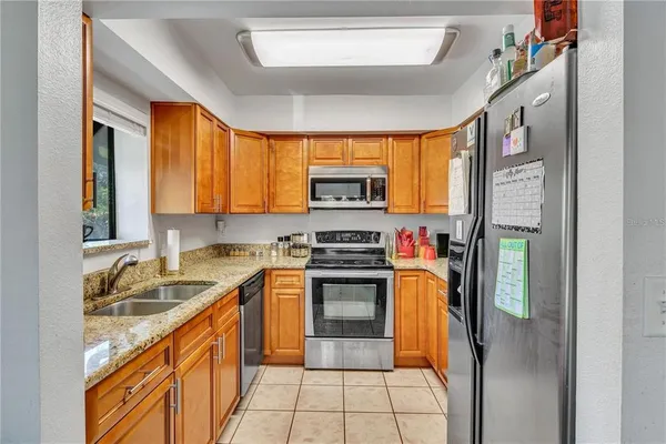 a kitchen with stainless steel appliances granite countertop a stove a sink and a refrigerator