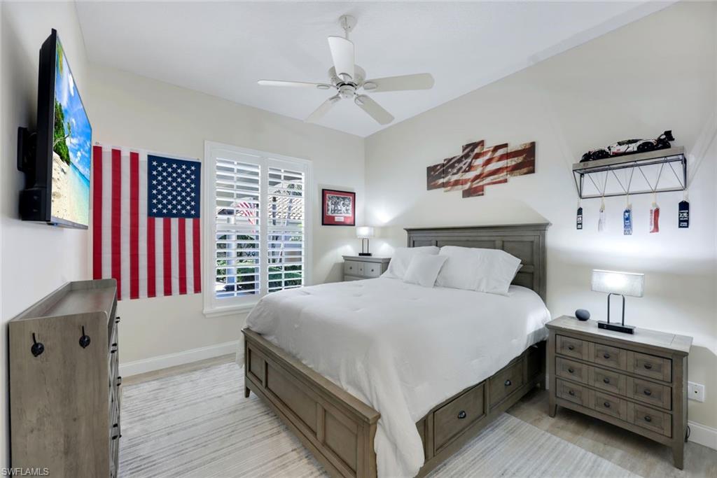 3108 Dominica Way Naples, FL 34119 - Photo 18 of 39 Light-filled room featuring wood-finish flooring, a ceiling fan, and window with white plantation shutters