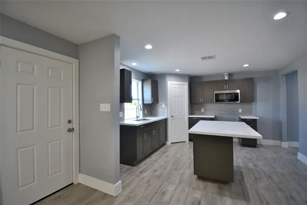 a large kitchen with kitchen island a sink counter space and stainless steel appliances