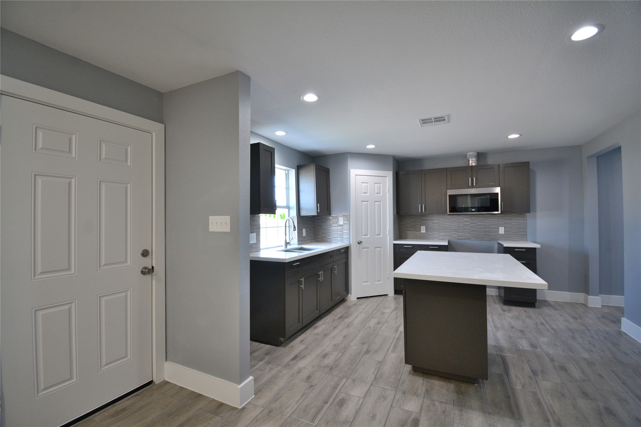 a large kitchen with kitchen island a sink counter space and stainless steel appliances
