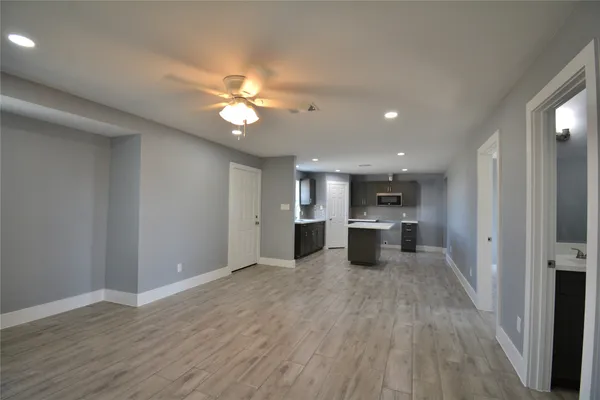a view of a kitchen with a sink and dishwasher a refrigerator with wooden floor