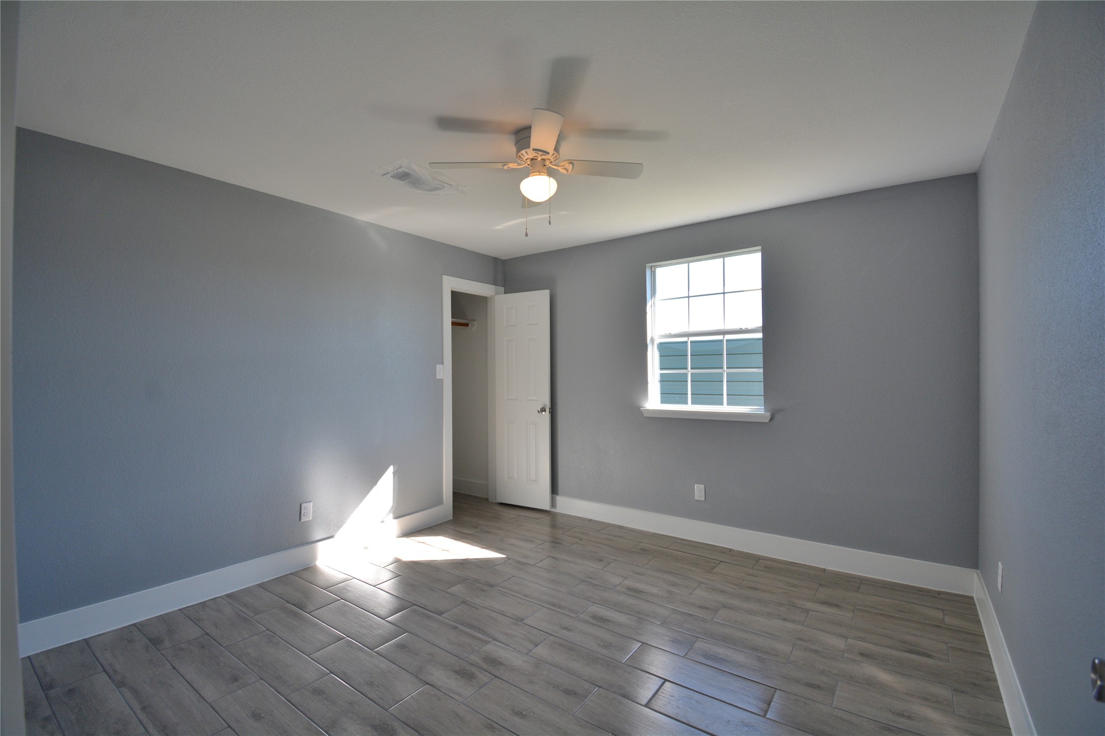 3335 Lafferty Road Pasadena, TX 77504 - Photo 3 of 13 wooden floor in an empty room with a window