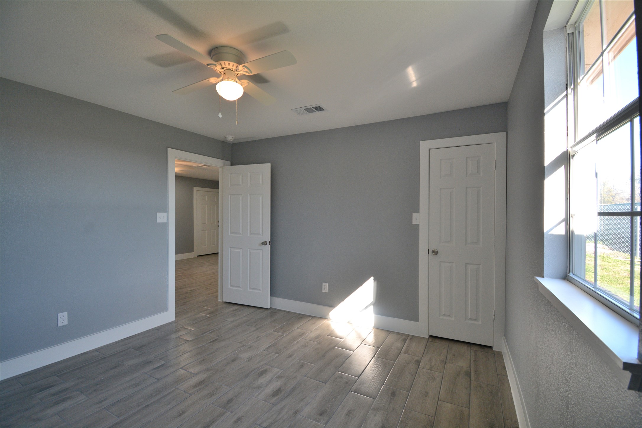 3335 Lafferty Road Pasadena, TX 77504 - Photo 4 of 13 a view of an empty room with wooden floor and a window