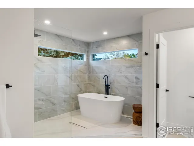 a spacious bathroom with a double vanity sink a large mirror and a bathtub