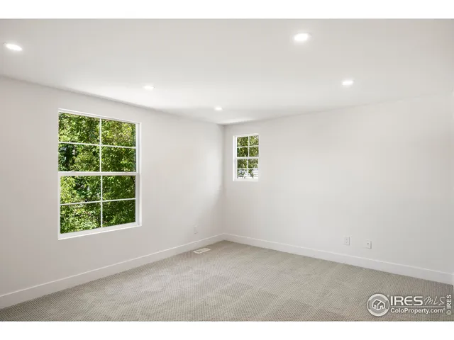 a living room with furniture a large window and wooden floors