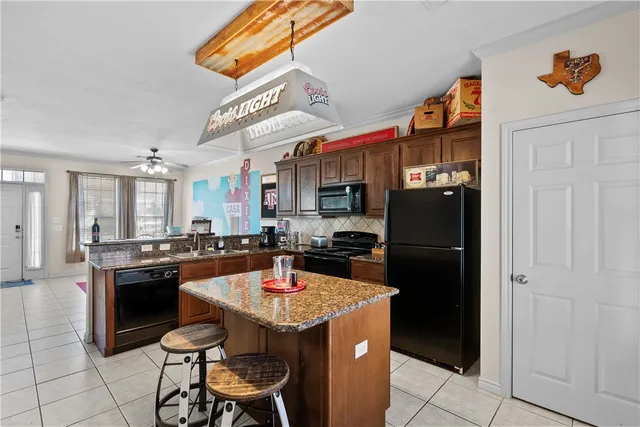 a kitchen with stainless steel appliances granite countertop a sink a stove and cabinets