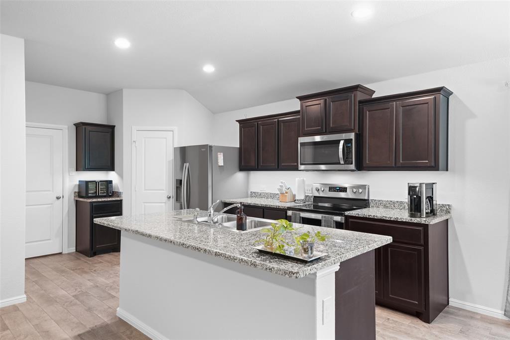 9020 Ridgeriver Way Fort Worth, TX 76131 - Photo 9 of 26 a kitchen with stainless steel appliances granite countertop a sink stove and refrigerator
