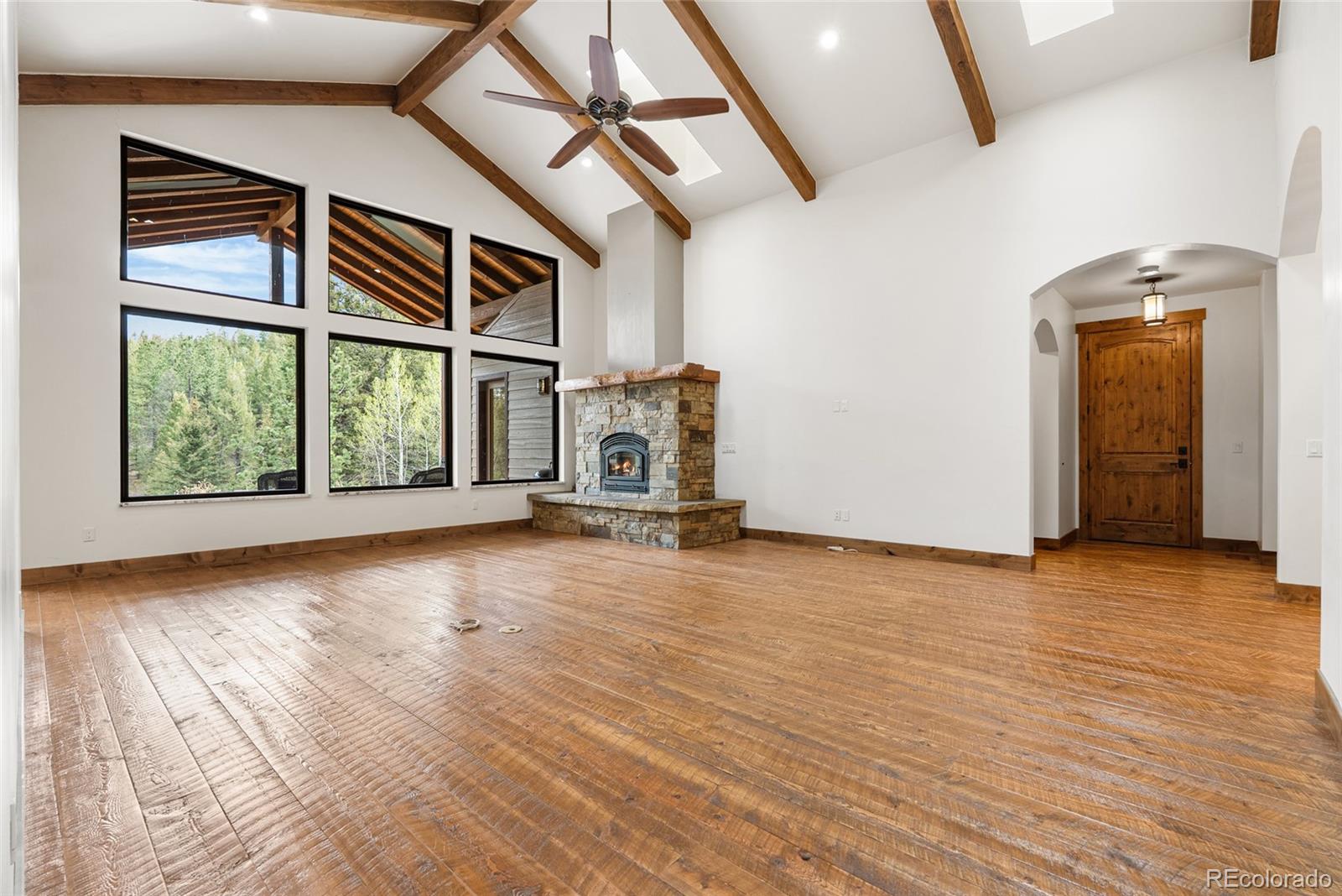280 Double Tree Road Bailey, CO 80421 - Photo 10 of 43 an empty room with wooden floor and windows