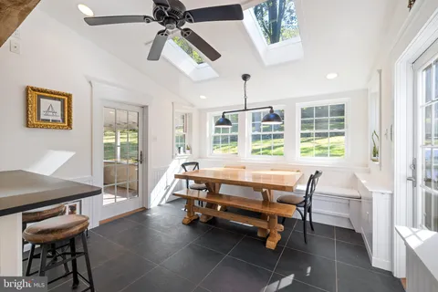 a living room with a dining table chairs and a chandelier