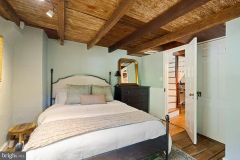 a bedroom with a bed and a dresser next to a window