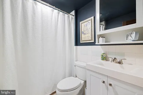 a bathroom with a sink a toilet and a window