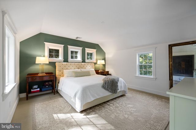 a spacious bedroom with a bed and a flat screen tv