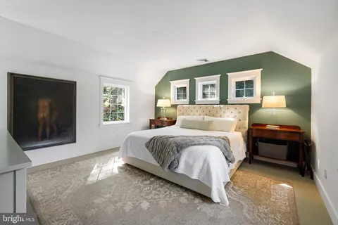 a spacious bedroom with a bed and a flat screen tv