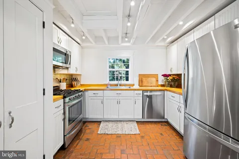 a kitchen with stainless steel appliances granite countertop a refrigerator a stove and a sink