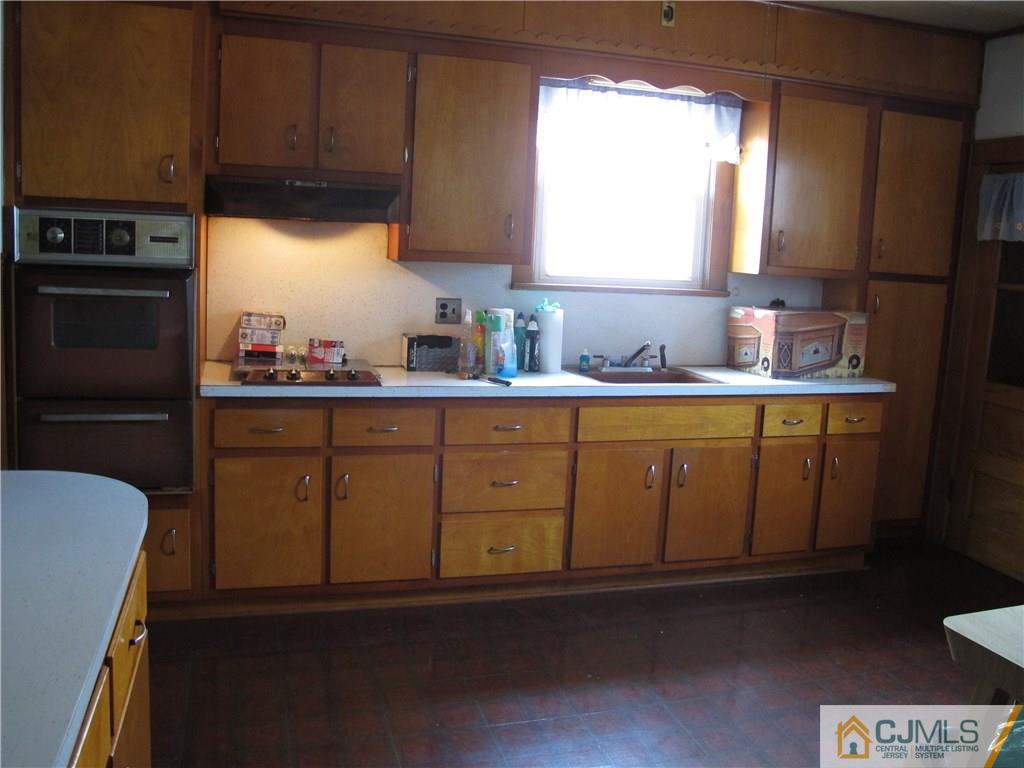 350 Summit Avenue Perth Amboy, NJ 08861 - Photo 4 of 20 a kitchen with stainless steel appliances granite countertop a sink a stove cabinets and a dining table