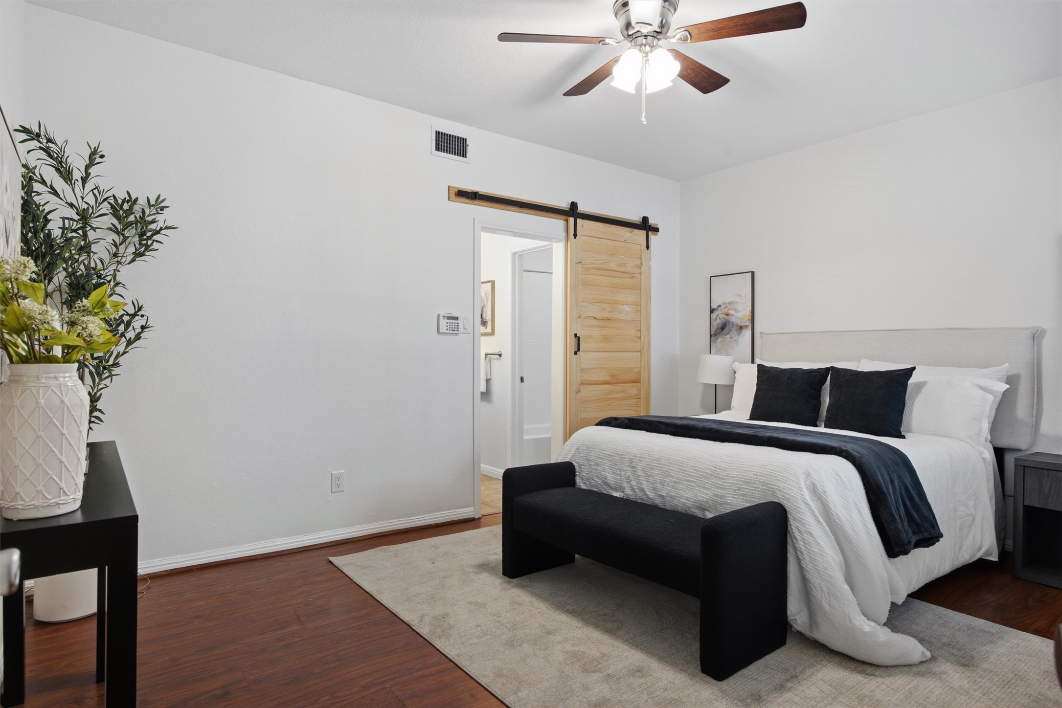 2529 Rio Grande Street, Unit 72 Austin, TX 78705 - Photo 13 of 24 a sliding barn door elevates the serene bedroom suite.