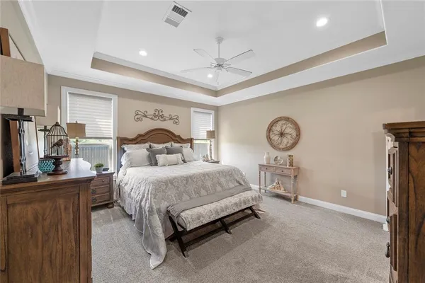 a spacious bedroom with a bed and a chandelier