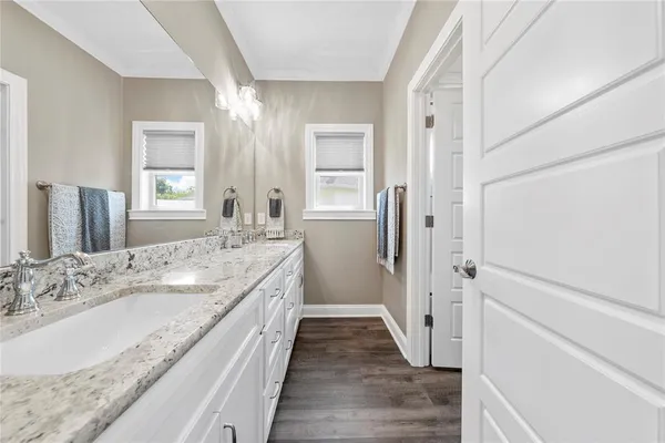 a bathroom with a granite countertop sink a mirror and a shower