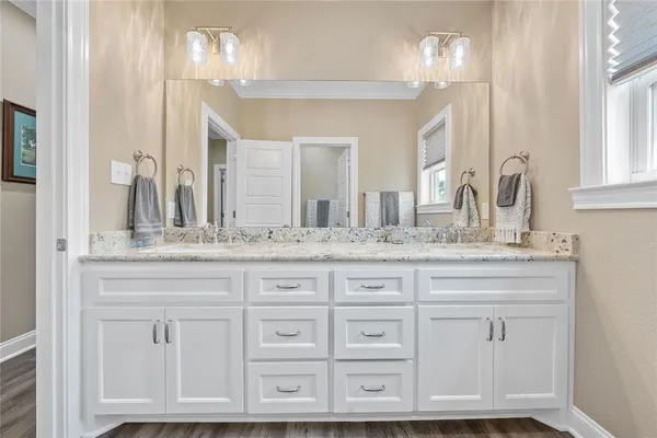 a bathroom with cabinets and chandelier