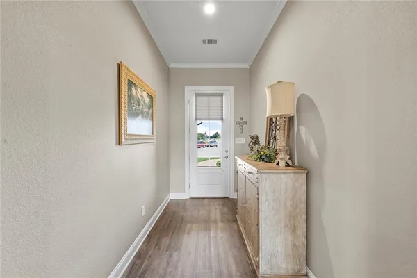 a view of a hallway with wooden floor and a living room