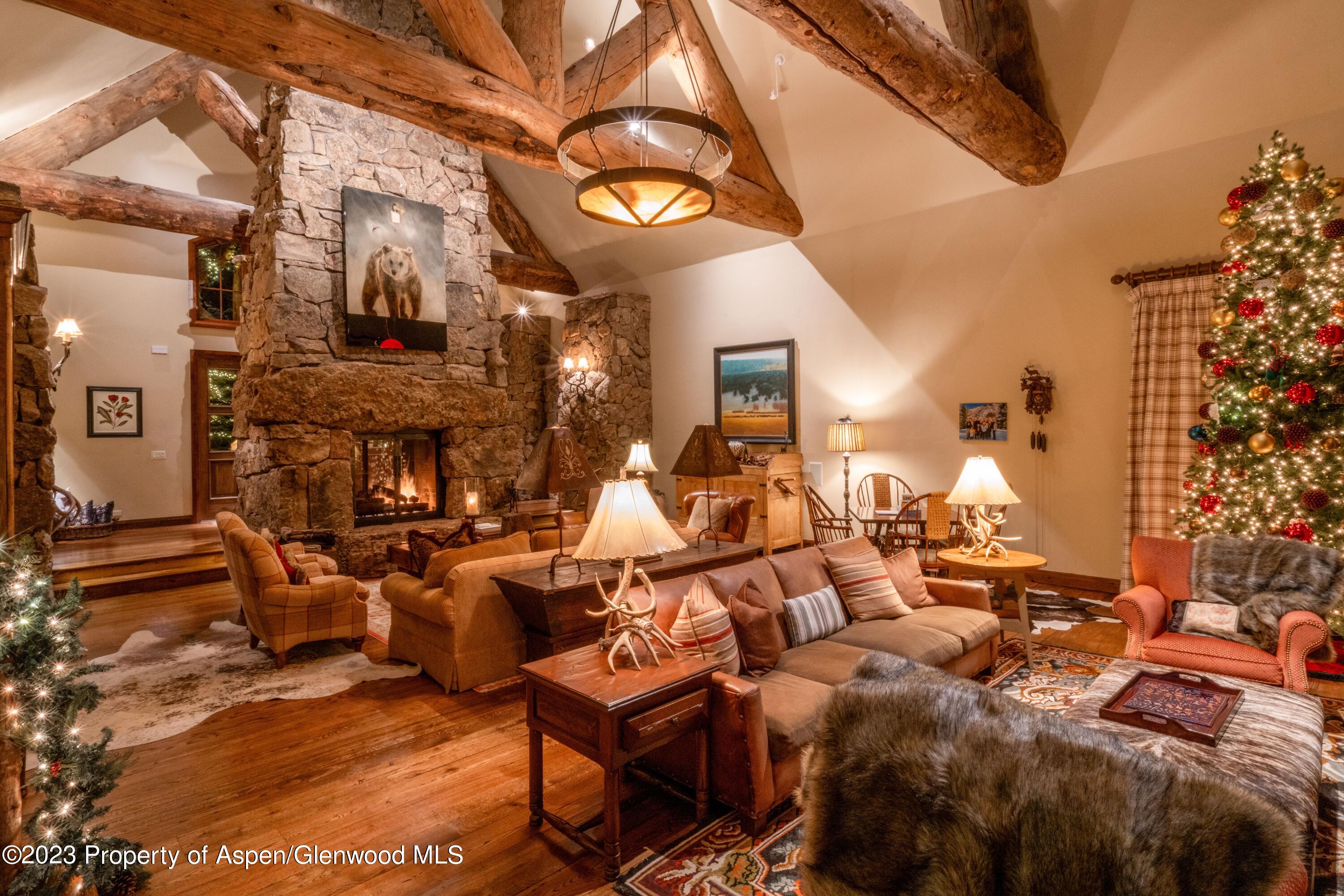 800 South Hayden Road Aspen, CO 81611 - Photo 13 of 60 a large living room with lots of white furniture and a fireplace