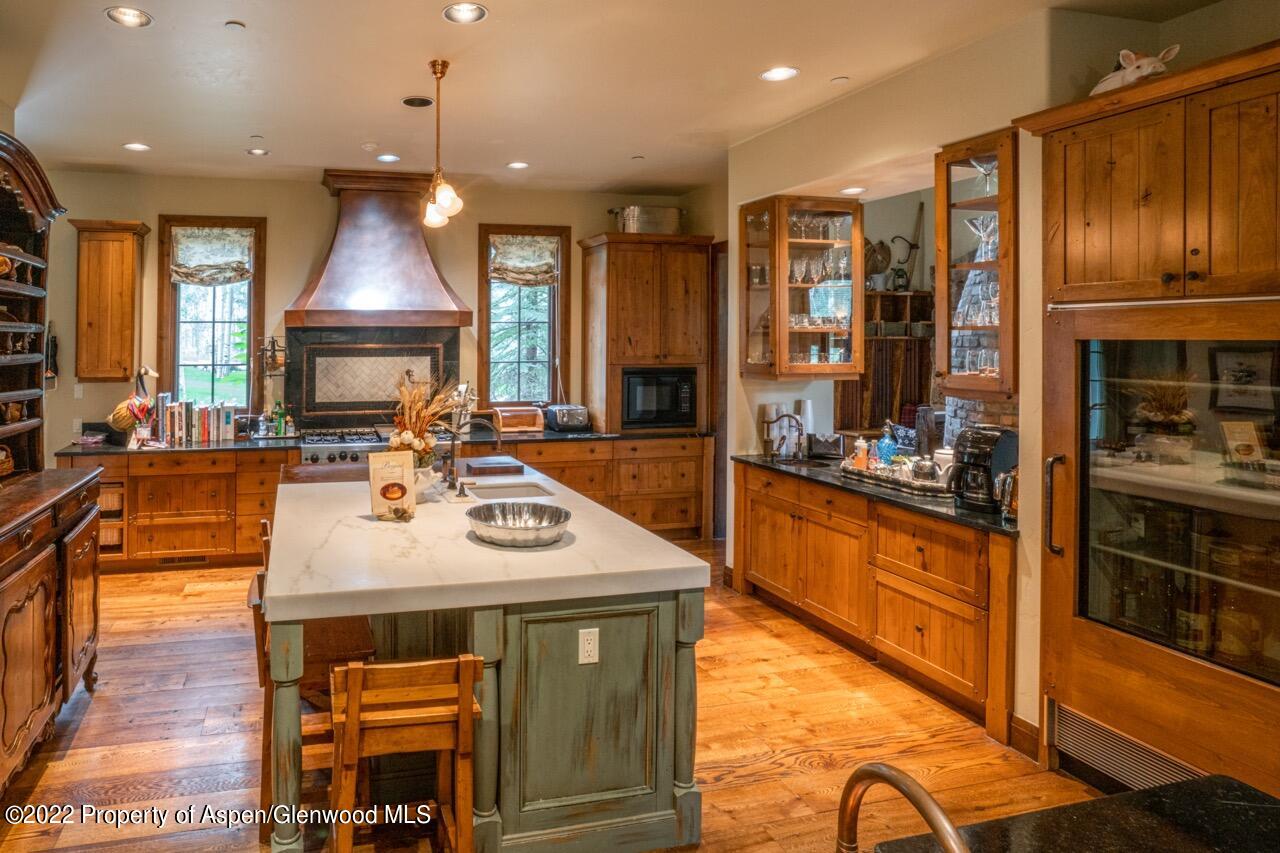 800 South Hayden Road Aspen, CO 81611 - Photo 28 of 60 a kitchen with sink a stove and chairs