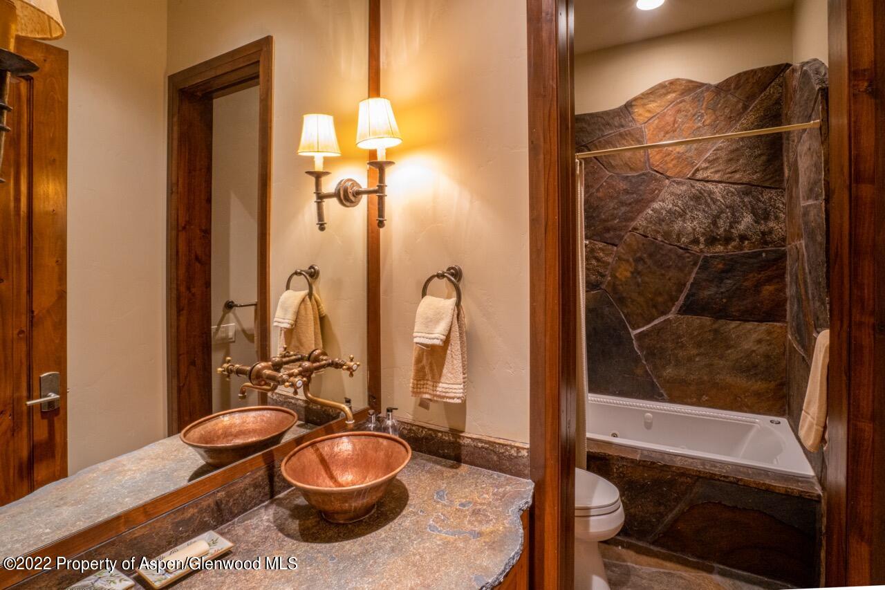800 South Hayden Road Aspen, CO 81611 - Photo 38 of 60 a bathroom with a granite countertop sink and a mirror