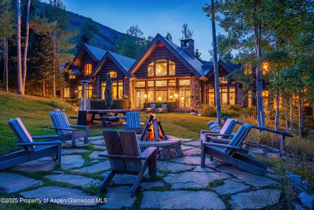 a large living room with lots of white furniture and a fireplace