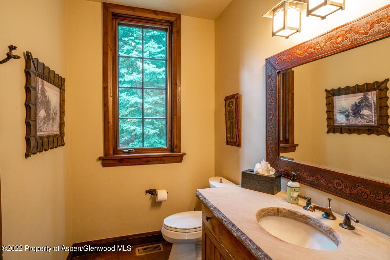 800 South Hayden Road Aspen, CO 81611 - Photo 54 of 60 a bathroom with a granite countertop toilet sink and mirror