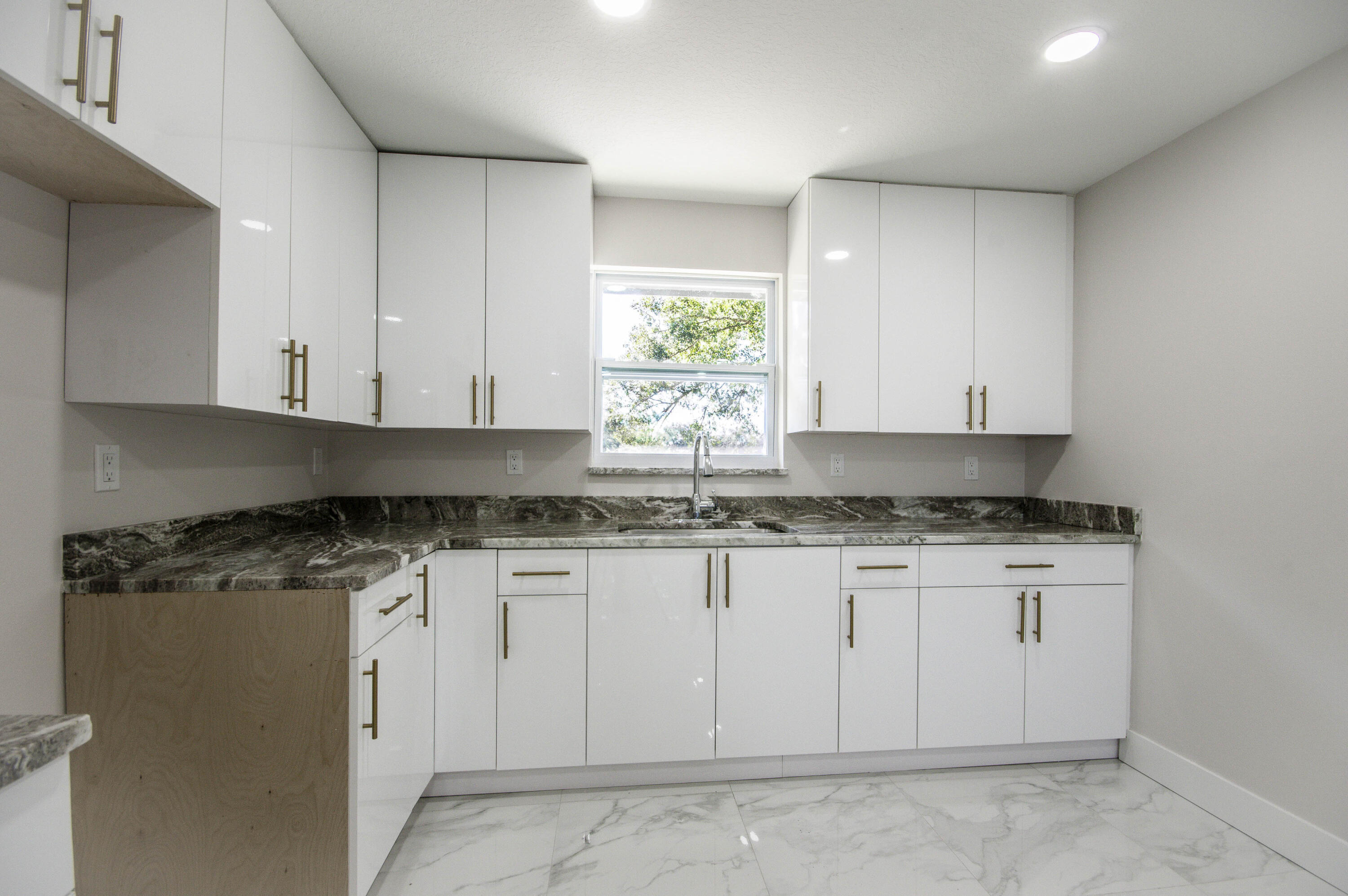 311 Southwest 67th Drive Okeechobee, FL 34974 - Photo 15 of 30 a kitchen with stainless steel appliances granite countertop a stove a sink and white cabinets