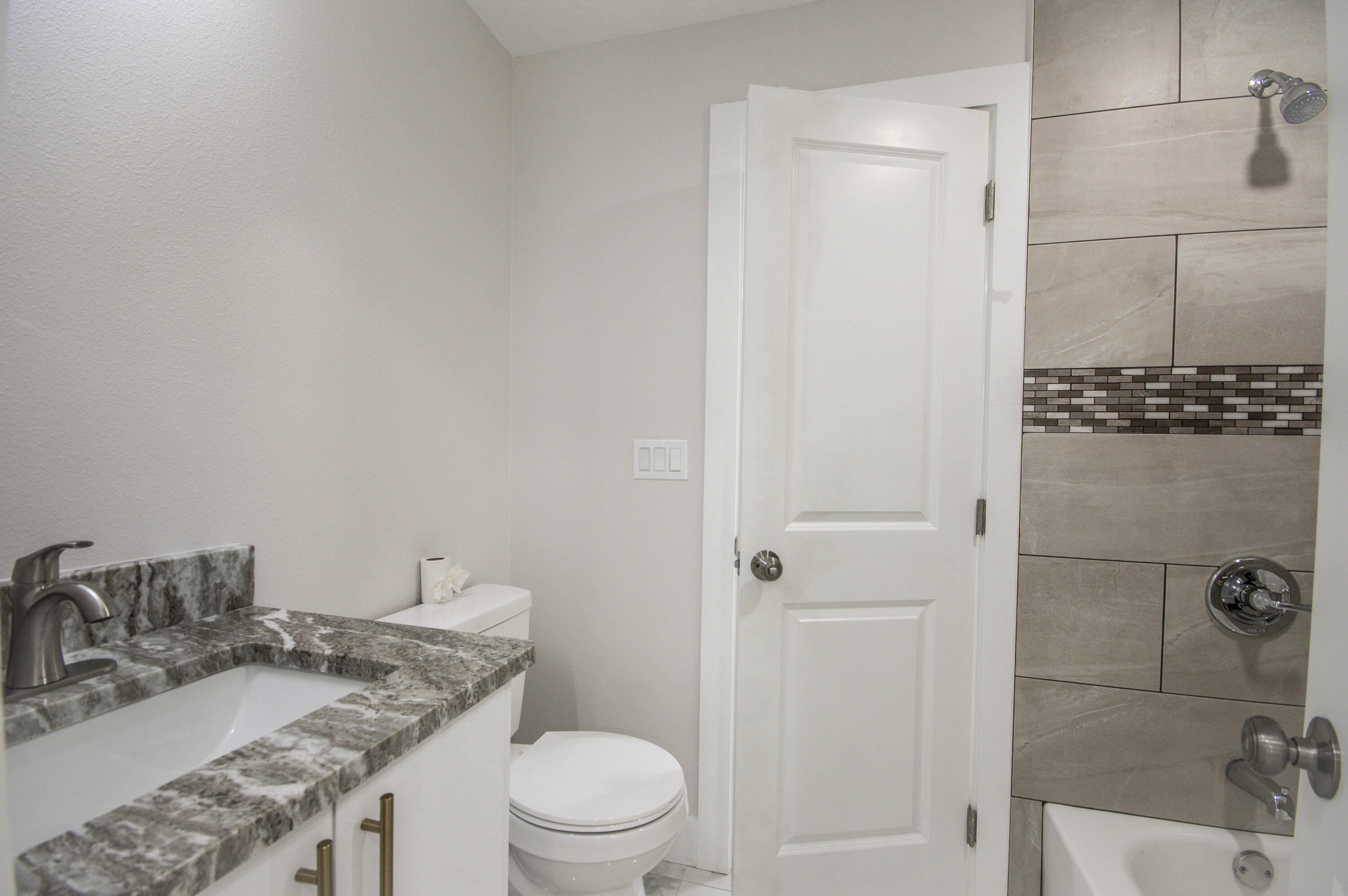 311 Southwest 67th Drive Okeechobee, FL 34974 - Photo 10 of 30 a bathroom with a granite countertop sink a toilet and shower