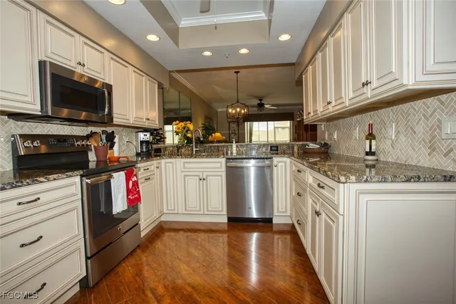 a kitchen with granite countertop a sink a stove top oven and cabinets
