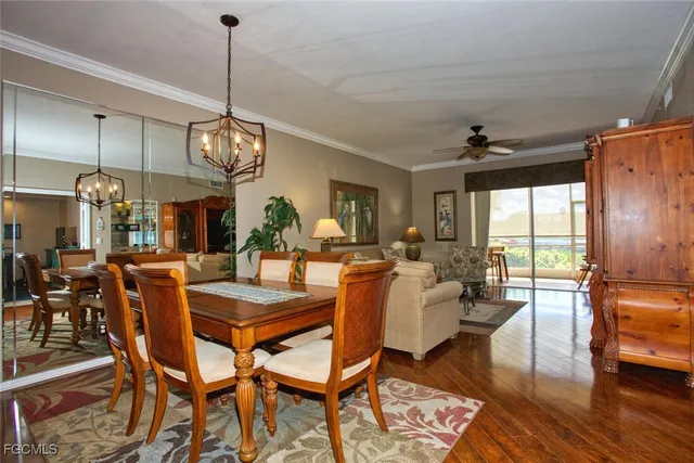 a view of a dining room and livingroom with furniture wooden floor a chandelier