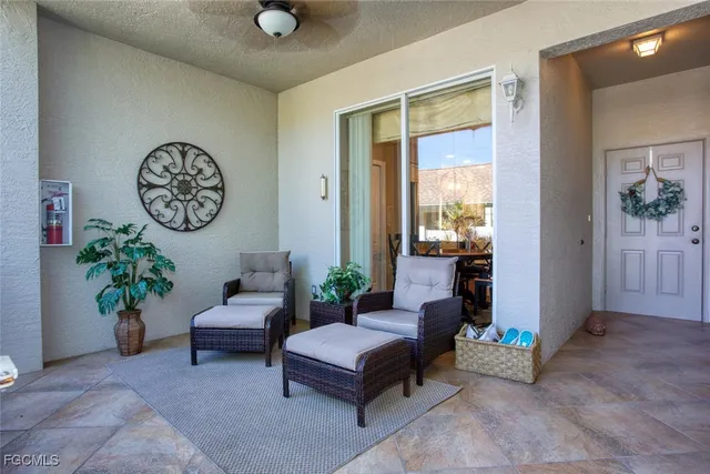 a living room with furniture flowers and a window