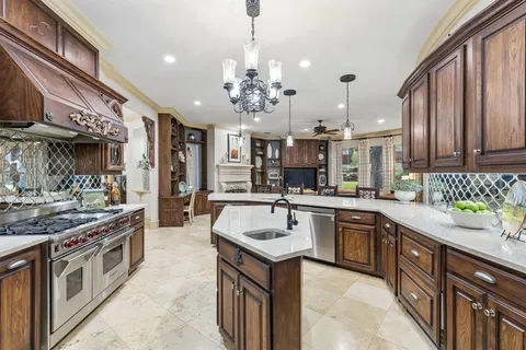 a large kitchen with stainless steel appliances granite countertop a sink and cabinets