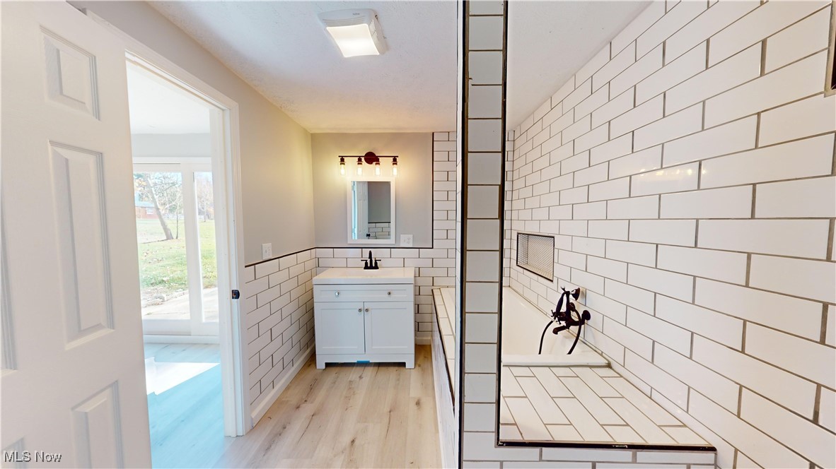 15245 Georgia Road Middlefield, OH 44062 - Photo 21 of 35 Bathroom featuring vanity, tile walls, and wood-type flooring