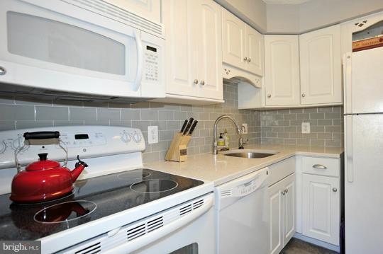 1301 North Courthouse Road, Unit 1507 Arlington, VA 22201 - Photo 2 of 16 a kitchen with stainless steel appliances granite countertop a sink stove and white cabinets