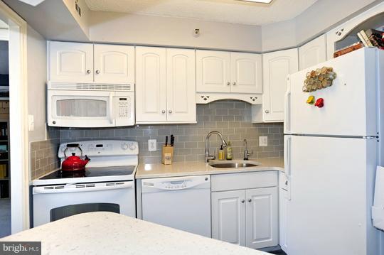 1301 North Courthouse Road, Unit 1507 Arlington, VA 22201 - Photo 9 of 16 a kitchen with white cabinets and white appliances