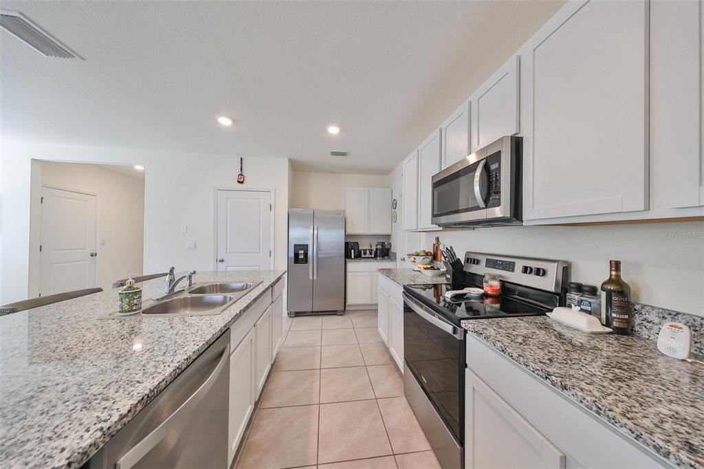3528 Maple Grv Way Plant City, FL 33565 - Photo 18 of 51 a kitchen with stainless steel appliances granite countertop a sink a stove and cabinets