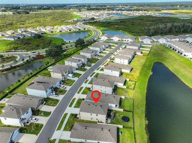 an aerial view of residential houses with outdoor space and parking