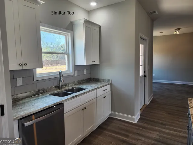 a view of an empty room with wooden floor and window