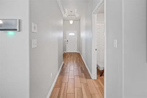 a bedroom with a bed a flat screen tv and a chandelier