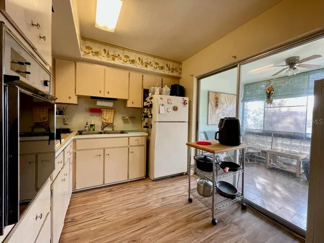 a kitchen with a refrigerator cabinets and wooden floor