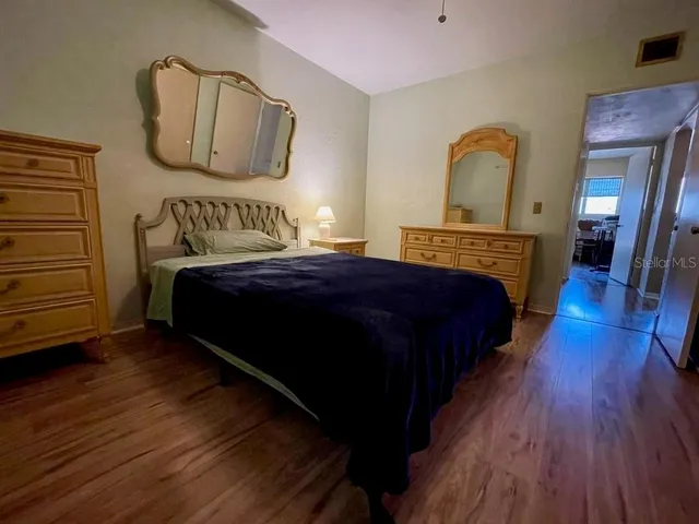 a bedroom with bed and wooden floor