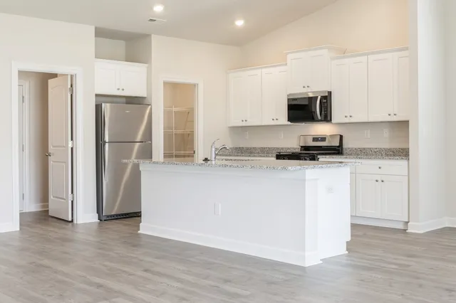 a kitchen with stainless steel appliances a refrigerator sink and microwave