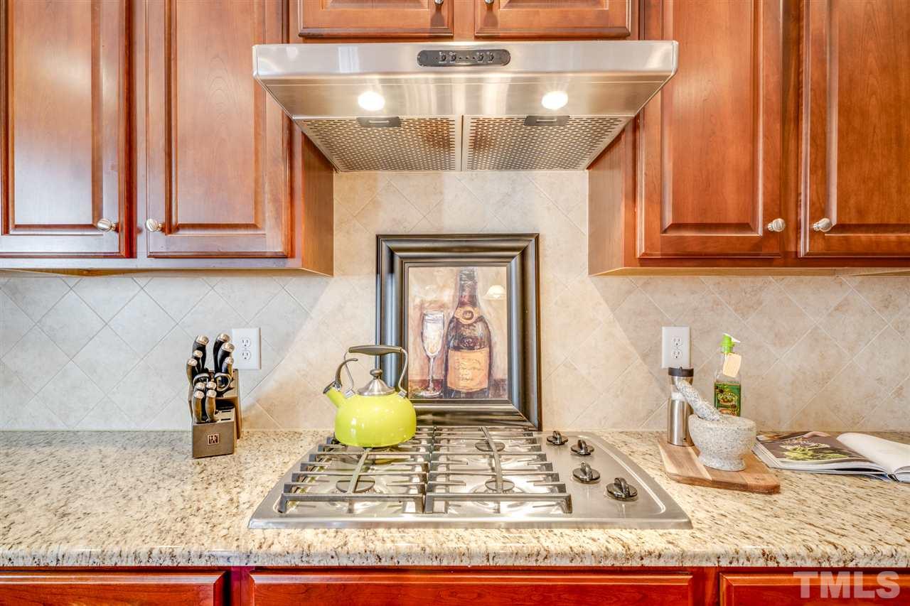 12819 Edsel Drive Raleigh, NC 27613 - Photo 12 of 30 a kitchen with a stove and a wooden cabinets