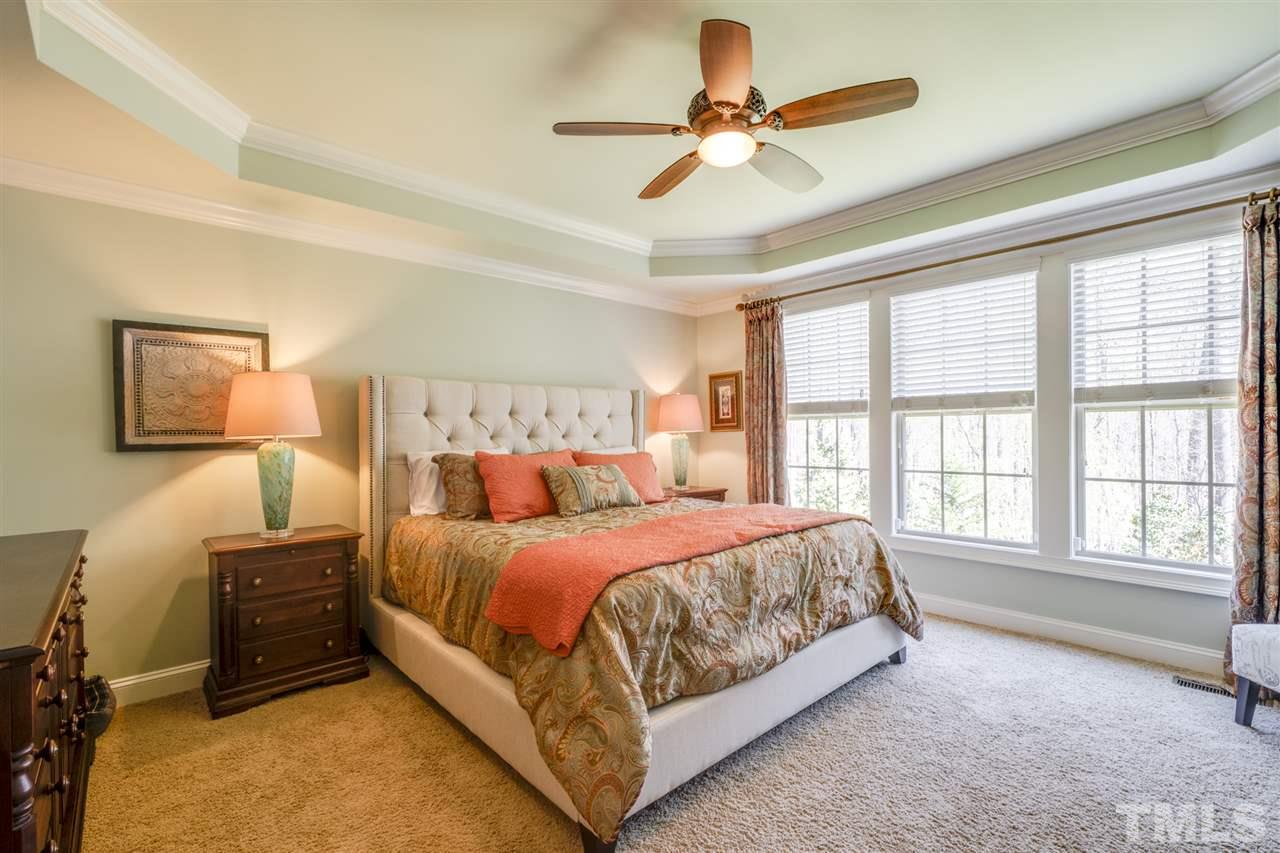 12819 Edsel Drive Raleigh, NC 27613 - Photo 15 of 30 a bedroom with a bed a ceiling fan and a large window